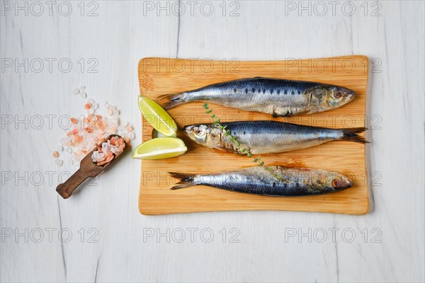 Overhead view of fresh gutted smelt on wooden cutting board