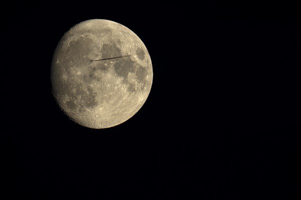 Moon with passing jet