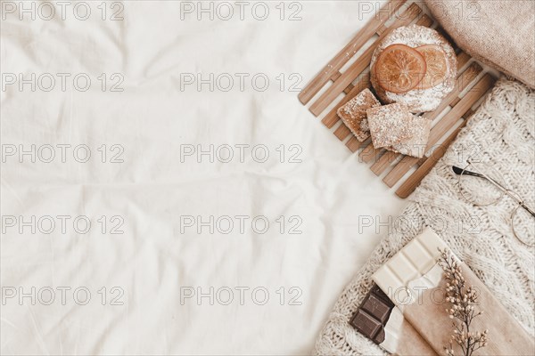 Pastry chocolates with herb plaid lying white bedsheet