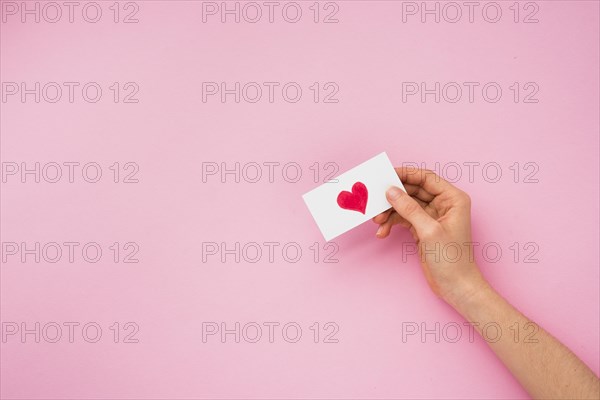 Person hand holding paper with heart picture