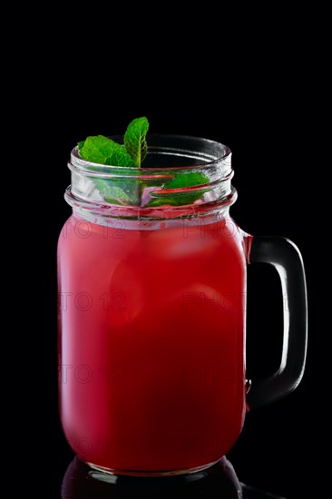 Mug with cranberry cocktail isolated on black background