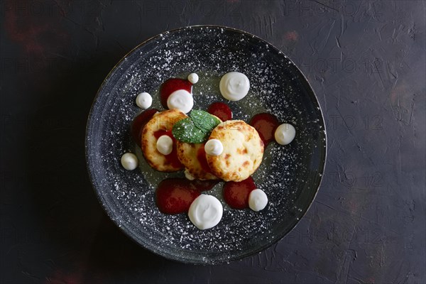 Cheese pancakes with sour cream and strawberry jam