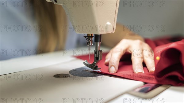 Close up hands sewing with machine