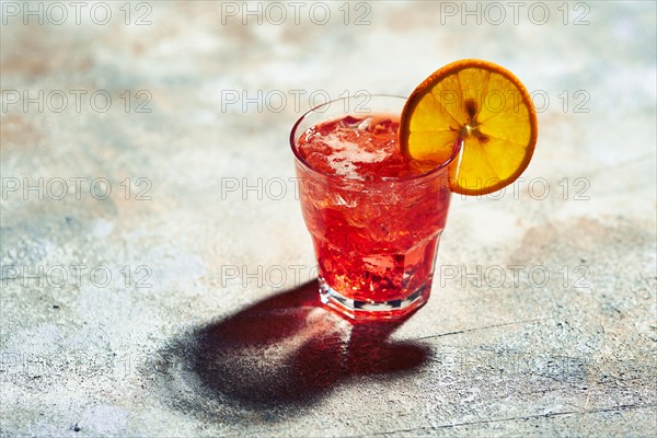 Cocktail boulevardier under sunlight with harsh shadows