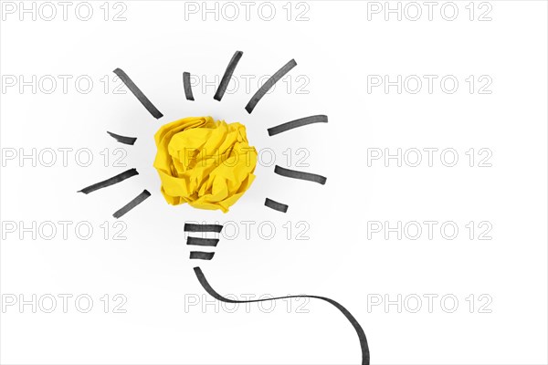 Idea concept with light bulb made out of yellow crumbled paper ball and drawn black lines on white background