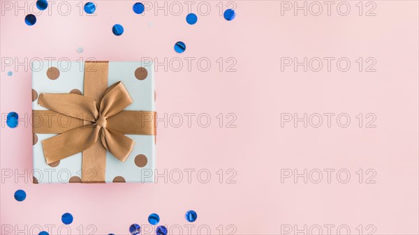 Wrapped present with brown bow and ribbon on pastel pink backdrop. Resolution and high quality beautiful photo