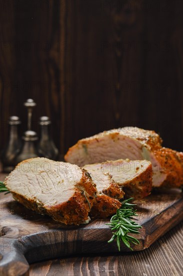 Closeup view of pork collar joint baked in oven on wooden cutting board