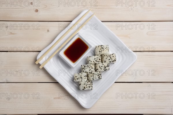 Top view of plate with salmon rolls with hashi and siy sauce