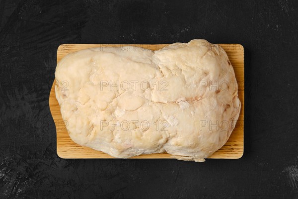 Overhead view of lamb fat tail on kitchen table with salt and pepper