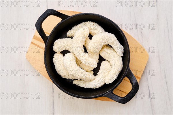 Top view of prepared for frying uncooked shrimps in cheese breading with spice