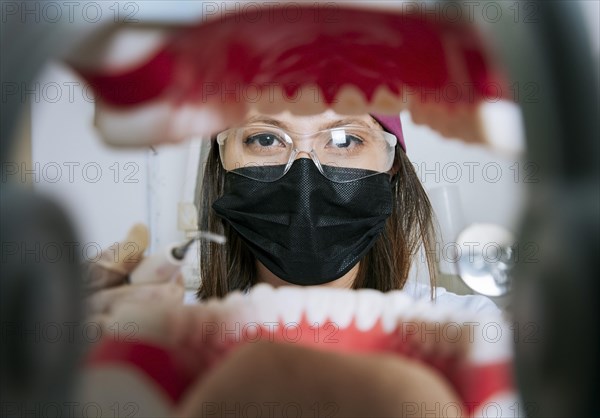 Woman dentist cleaning a mouth inside view