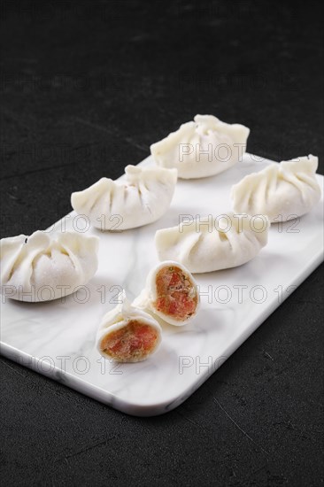 Frozen dumplings stuffed with liver and provencal herbs on marble serving plate