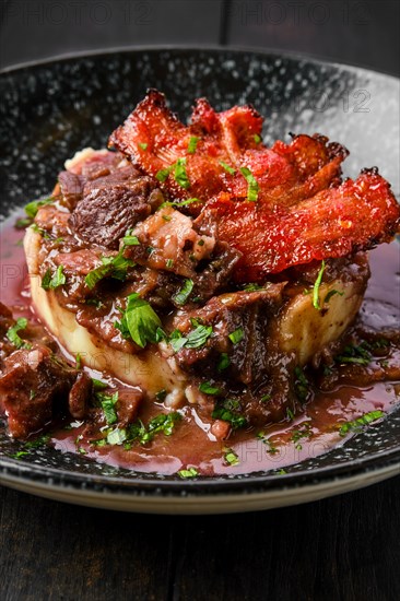 Closeup view of beef goulash with bacon chips