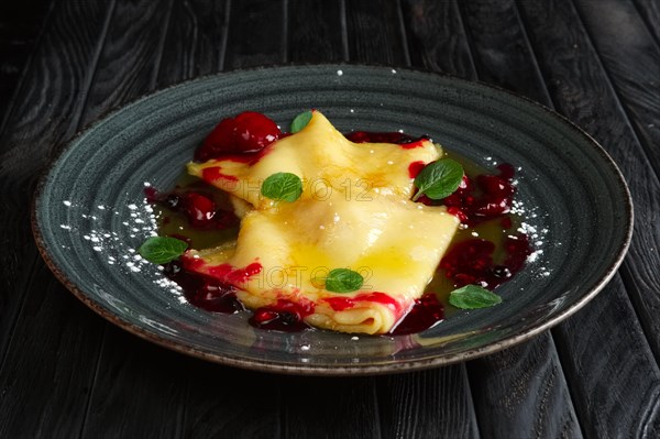 Pancakes with cherry jam decorated with mint leaves