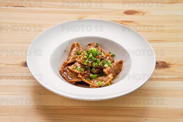 Deep-fried japanese gyoza or dumplings snack with soy sauce on wooden table