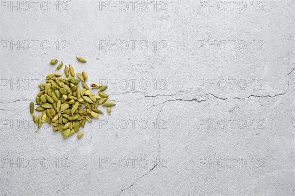 Overhead view of pile of cardamom on abstract background