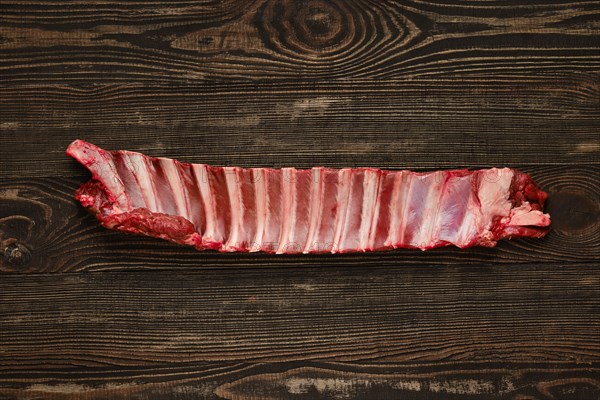 Overhead view of raw deer ribs over wooden background