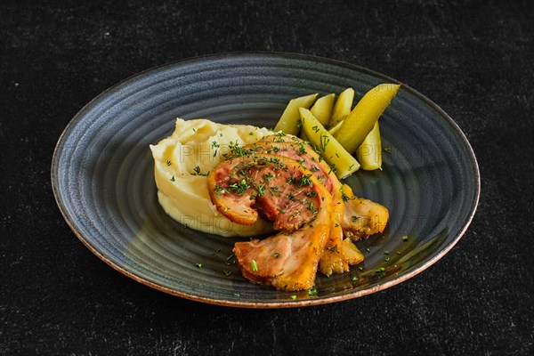 Baked bacon with mashed potato and pickle cucumber