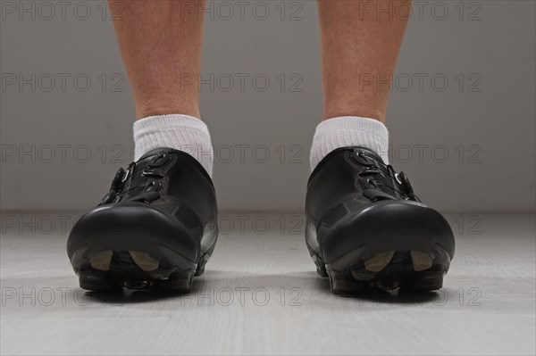 Low point of view of male legs in cycling boots