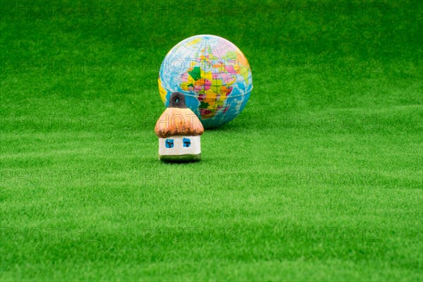 Hut near a globe on green grass