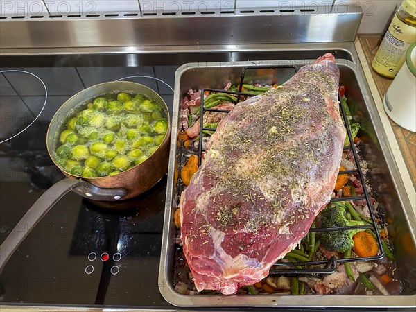 Raw leg of lamb in a roaster with vegetables and spices. Hesse