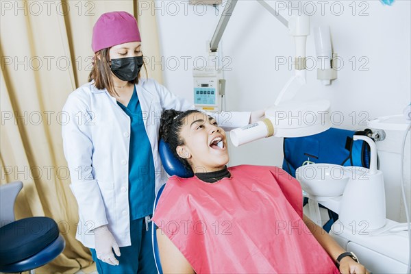 Dentist performing intraoral dental x-ray on a patient