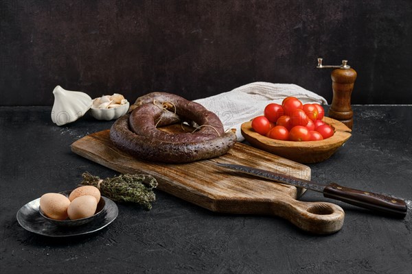 Blood sausage rolled on wooden cutting board