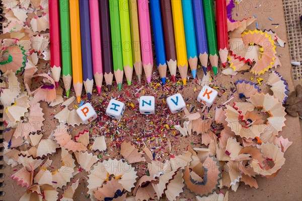 Color Pencils and letter cubes on the pencil shavings