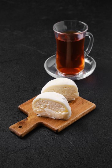 Sweet dessert mochi with coconut chips cut on half with fruit tea