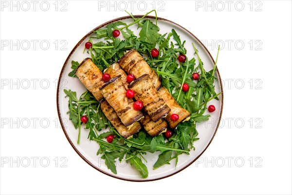 Eggplant rolls stuffed with soft cheese and garlic decorated with arugula and cranberry