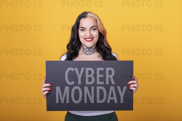 Beautiful woman pointing at a Cyber Monday sign. Commercial concept. Commerce