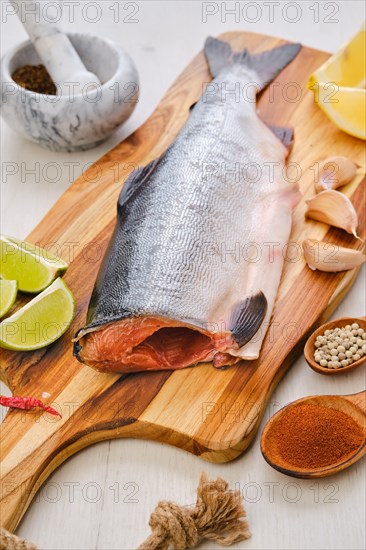 Raw fresh headless pink salmon on wooden cutting board