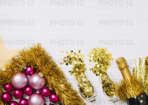 Champagne bottle with shiny baubles on table