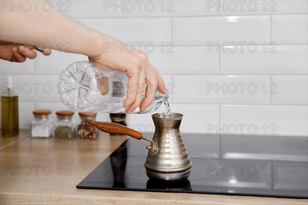 Man makes coffee in cezve