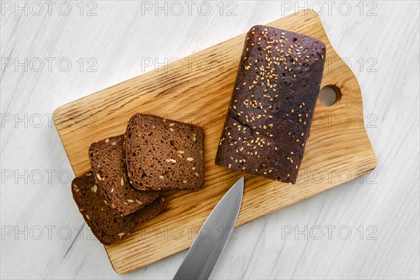 Top view of loaf of brown sourdough bread with sunflower seeds and sesame