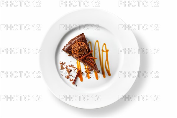 Overhead view of chocolate cake with caramel sauce isolated on white