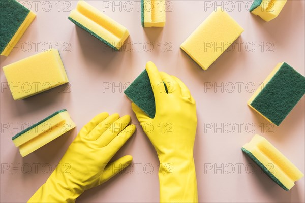 Close up person with yellow gloves sponges