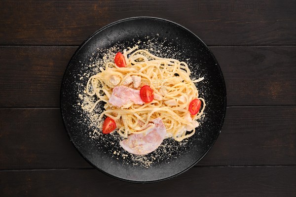 Spaghetti with ham and tomatoes sprinkled with grated parmesan