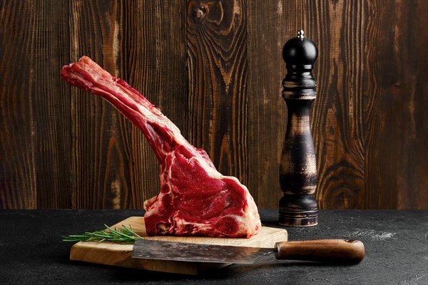 Raw prime ribeye steak on wooden cutting board