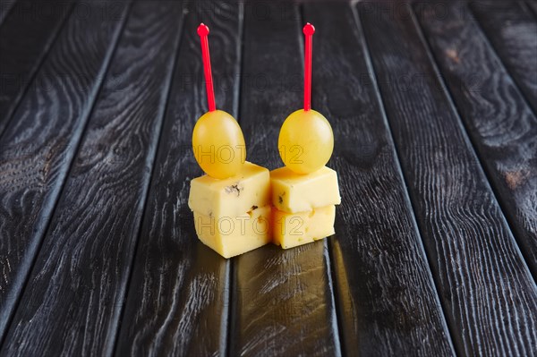 Appetizer for reception. Two kinds of cheese and grape on skewer