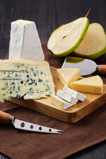 Assortment of cheese and snack for wine on dark wooden table