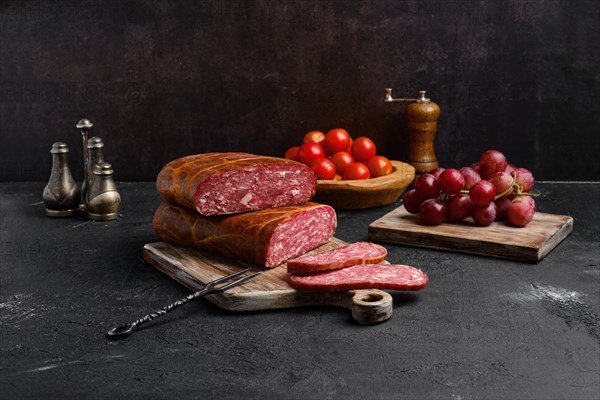 Homemade smoked beef sausage in organic casing on wooden cutting board