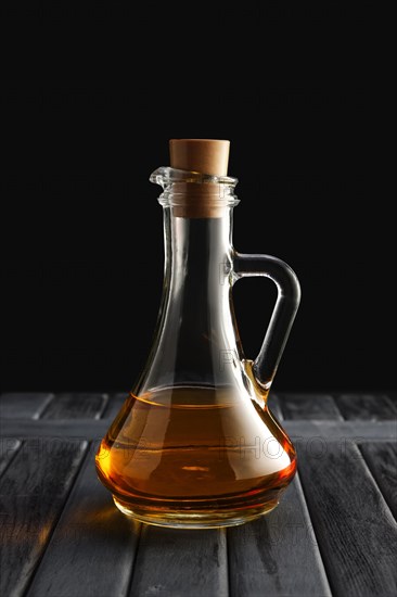 Jar with olive oil on wooden table