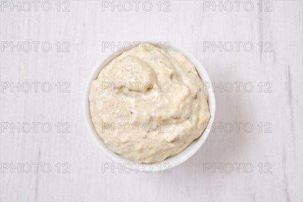 Overhead view of small bowl with caesar sauce for salad