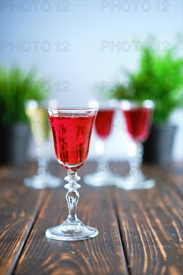 Vodka infused with berries on wooden background