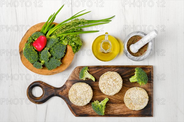 Top view of semifinished homemade chicken cutlet with broccoli on a wooden serving board