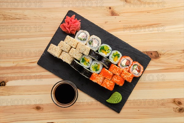 Big set of rolls with traditional garnish on wooden table