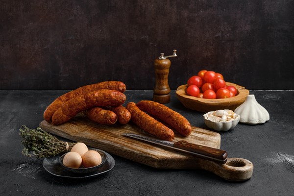 Homemade hot moked beef sausage in organic casing on wooden cutting board