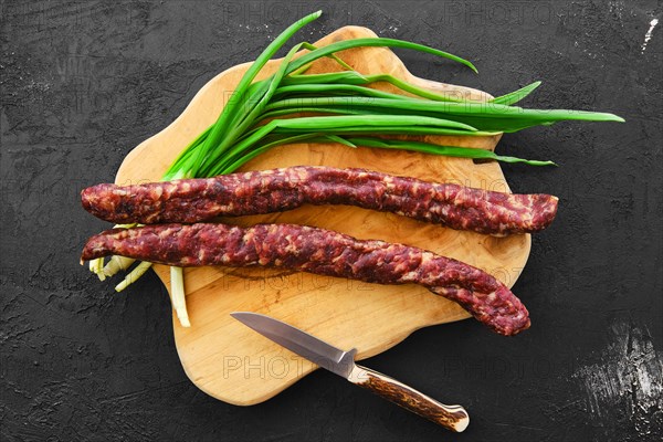 Top view of sun-dried pork sausage on wooden cutting board