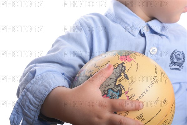Baby with blue shirt holding a globe in hand on white background